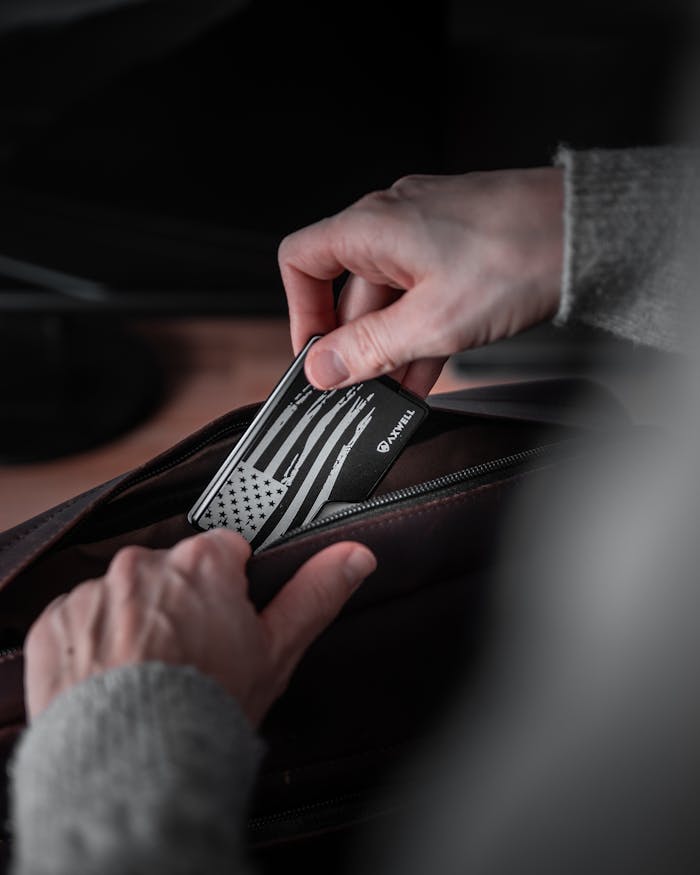 Close-up of hands placing a patriotic card into a bag, showcasing detailed textures.