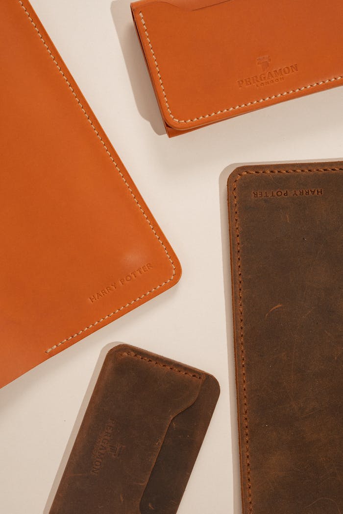 Leather accessories arranged aesthetically with visible brand names and textured finishes.
